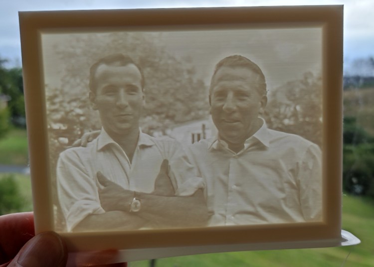 A 3D printed Lithophane being held up to the light to reveal the image hidden inside.