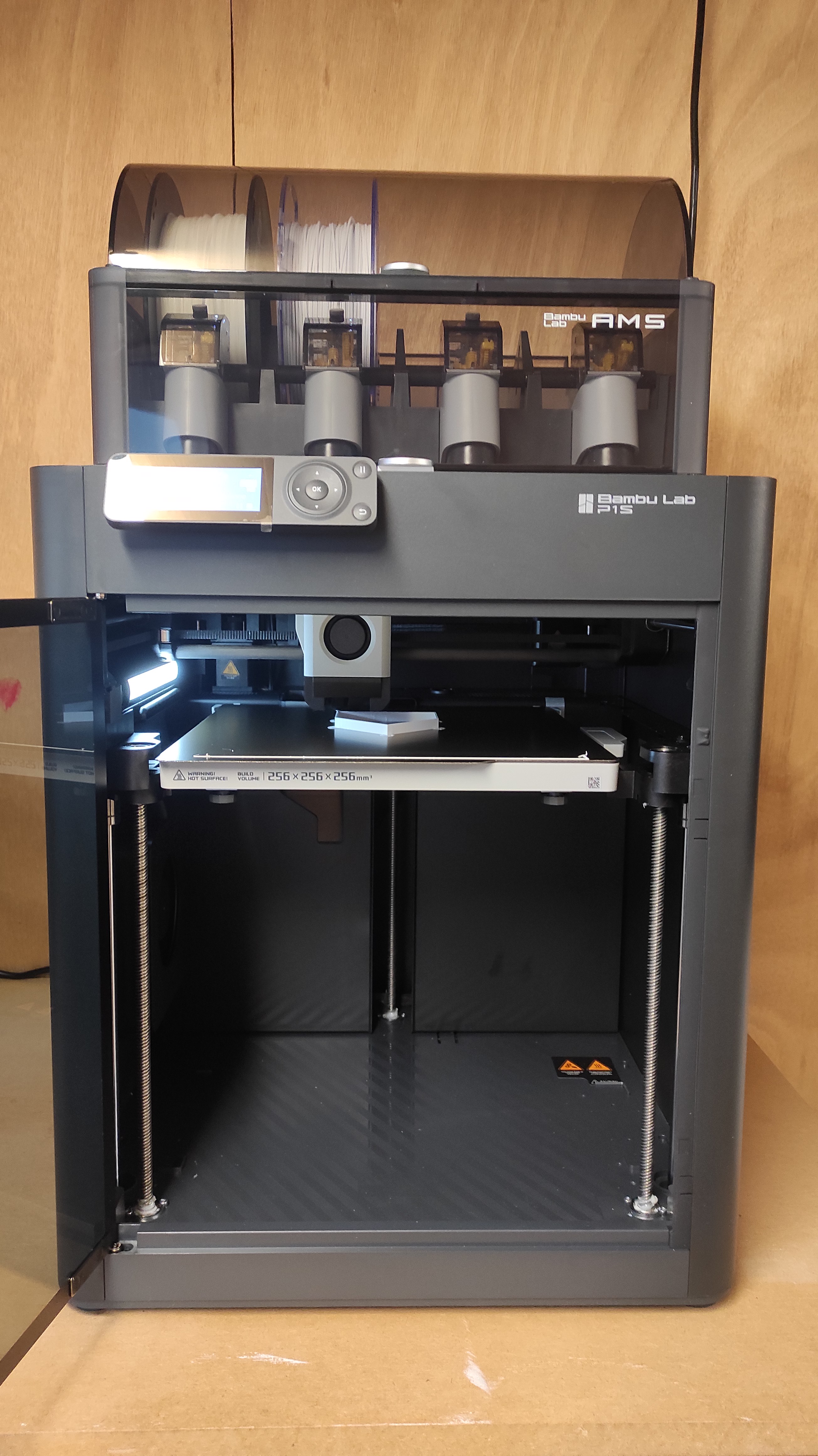 3D printer printing an object with the enclosure door open.