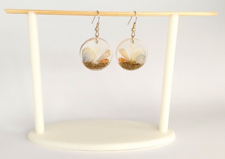Earrings hang on a 3D printed stand.